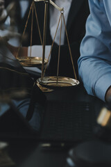 Business and lawyers discussing contract papers with brass scale on desk in office. Law, legal services, advice, justice and law concept picture with film grain effect