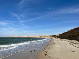 Fototapeta na wymiar Scenic view of sandy Dakhla beach against the sea waves on a sunny day