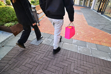 Low angle view  of person walking carrying shopping bags selective focus deliberated motion blur