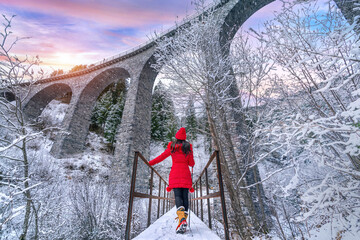 Tourist visiting Landwasser Viaduct world heritage in Swiss Alps snow winter scenery, Switzerland.
