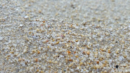 Macro shot of sand grains in shades of grey, white, and brown.