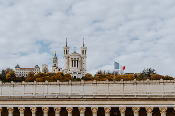 Blick auf eine Kirche auf den Hügeln von Lyon in Frankreich und eine französische Fahne