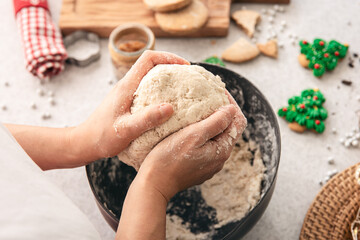 Female hands kneading dough for Christmas cookies, top view.