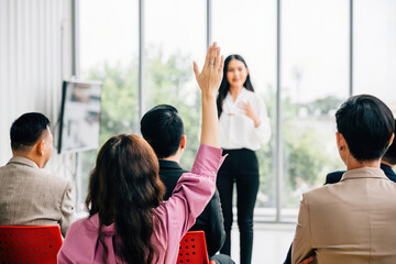 Obraz premium A large group in a seminar classroom raises their hands, actively participating and engaged in the discussion. The audience has the answer in this dynamic conference setting.