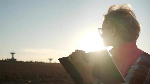 Woman operator equipment tablet pc controls solar radio telescope antennas. Move camera
