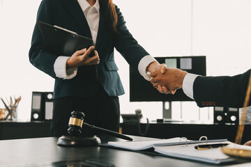 Businessman shaking hands to seal a deal with his partner lawyers or attorneys discussing a...