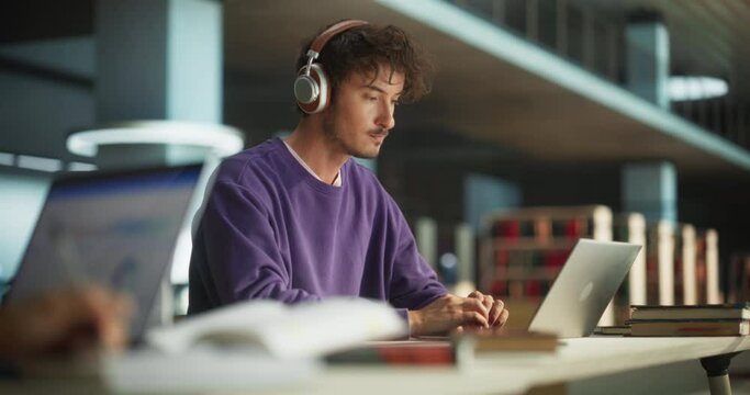 Close Up Footage of a Person Writing in Notebook. Focus Switching to a Thoughtful College Student Using Laptop Computer for Studying in a Library. Handsome Man Learning Online, Getting Ready for Exams