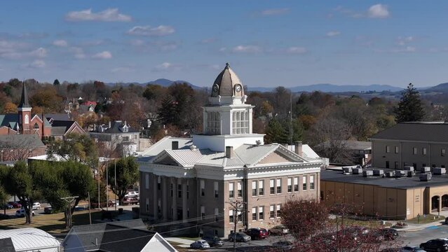 A rotating aerial establishing shot of the domed Wytheville, Virginia city courthouse on an autumn day. Church steeples and the Appalachian Mountain range in the distance.  	