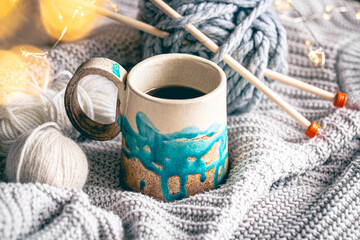 Fototapeta na wymiar Cozy composition with a cup of coffee, threads and a knitted element.