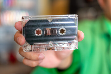 The hand's man holding old audio tape cassette,1980s songs tapes and stereo music cassettes. 90s...
