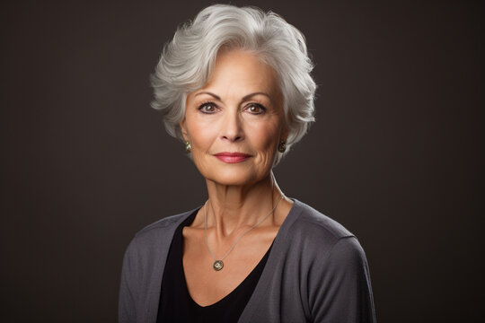 A elderly woman radiates charm in her golden years, set against a plain background