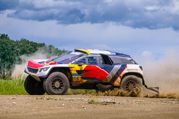 side view racing auto moving on terrain road during cross country rally