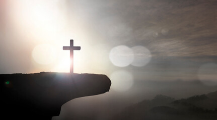 Christian holding the Holy Cross of Jesus Christ on sunset background