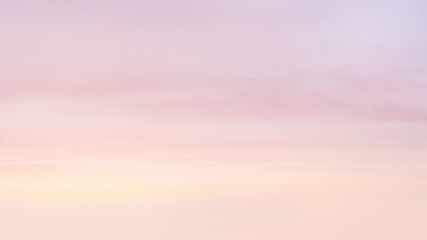 Colorful sky with soft and blur pink, purple, yellow pastel colored clouds. Copy space wallpaper.
