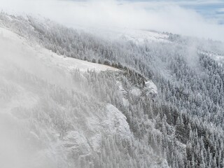 Aerial shot of a majestic snow-covered mountain range.