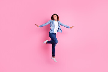 Carefree woman jumping against pastel background - obrazy, fototapety, plakaty