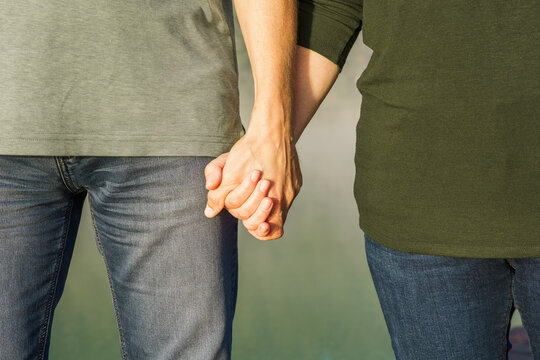 Eine Mann und eine Frau halten sich an der Hand. Nahaufnahme. Liebe, Ehepaar.