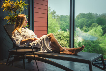 Woman in white bathrobe lying on sofa and relaxing at SPA. - obrazy, fototapety, plakaty