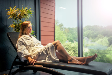 Woman in white bathrobe lying on sofa and relaxing at SPA. - obrazy, fototapety, plakaty