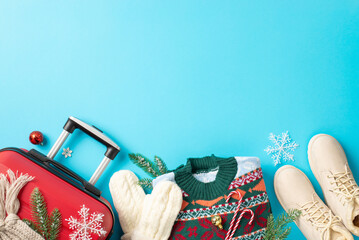 Yuletide voyage concept. Top view picture showcasing red suitcase, winter boots, cozy scarf,...