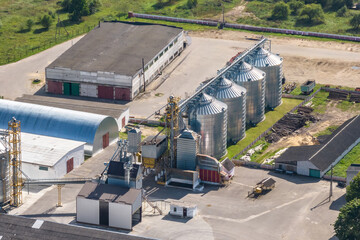aerial view on agro silos granary elevator with seeds cleaning line on agro-processing manufacturing plant for processing drying cleaning and storage of agricultural products, flour and grain.