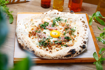 White pizza with egg, bacon, cheese and fresh herbs. Carbonara pizza, top view.