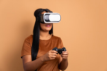 joyful black young woman playing videogame with VR headset in beige background. virtual reality, gaming, leisure concept.