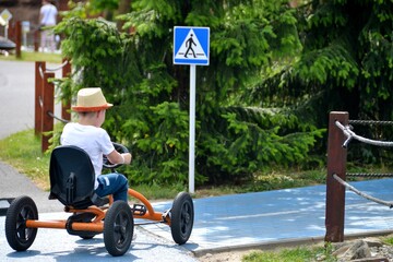 boy driving quad bike, four wheel cycle car, spring brightly morning, sunny day