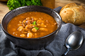 Beans with tomato sauce, bacon and sausage.