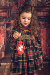 Girl in a Christmas decoration with a lantern in her hand