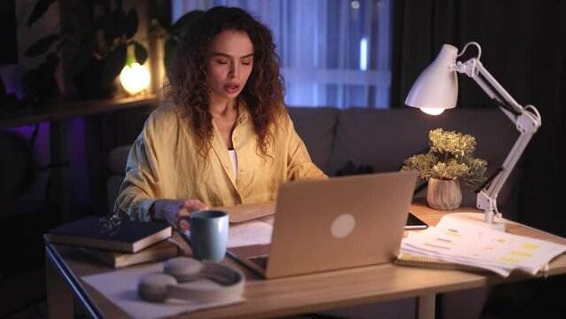 Worried young curly woman checking mail open envelope and reading bad negative news exam result rejection letter feeling disappointed at night at home Defeat Loss Disappointment concept