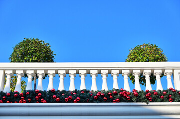 detail of red christmas baubles decor arrangement on elegant building facade