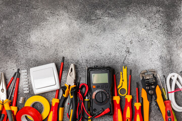 Electrician equipment on marble background with copy space.Top view.Electrician tool set.Multimeter, tester,screwdrivers,cutters,duct tape,lamps,tape measure and wires.Flet lay. © Avocado_studio