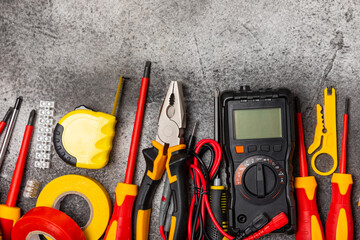 Electrician equipment on marble background with copy space.Top view.Electrician tool set.Multimeter, tester,screwdrivers,cutters,duct tape,lamps,tape measure and wires.Flet lay. © Avocado_studio