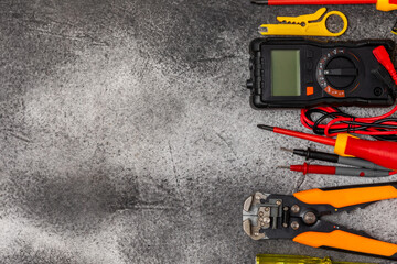 Electrician equipment on marble background with copy space.Top view.Electrician tool set.Multimeter, tester,screwdrivers,cutters,duct tape,lamps,tape measure and wires.Flet lay. © Avocado_studio