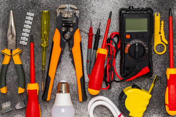 Electrician equipment on marble background with copy space.Top view.Electrician tool set.Multimeter, tester,screwdrivers,cutters,duct tape,lamps,tape measure and wires.Flet lay. © Avocado_studio