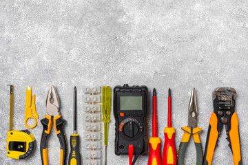 Electrician equipment on marble background with copy space.Top view.Electrician tool set.Multimeter, tester,screwdrivers,cutters,duct tape,lamps,tape measure and wires.Flet lay. © Avocado_studio