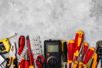 Electrician equipment on marble background with copy space.Top view.Electrician tool set.Multimeter, tester,screwdrivers,cutters,duct tape,lamps,tape measure and wires.Flet lay. © Avocado_studio
