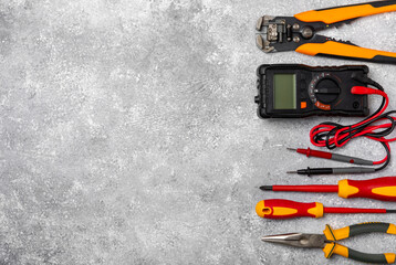 Electrician equipment on marble background with copy space.Top view.Electrician tool set.Multimeter, tester,screwdrivers,cutters,duct tape,lamps,tape measure and wires.Flet lay. © Avocado_studio