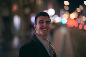 Smiling Meedle Eastern man walking down street near modern office building,