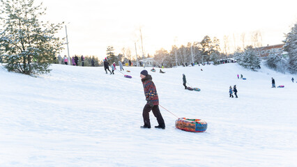 Vladimir, Russia, January 04, 2023: people ride down an ice slide in the park