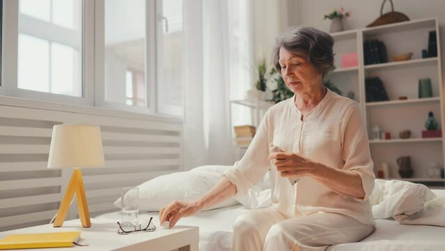 Woman in her 70s putting skin ointment on dry elbows, hormonal therapy, health