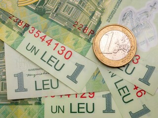 Romanian one leu banknotes and a one euro coin