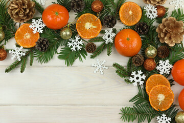 white wooden winter background with christmas decorations, tangerines, cones and copy space
