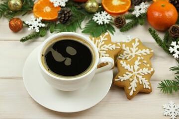 Obraz na płótnie Canvas cup of coffee on the white wooden winter background with christmas decorations, tangerines, cones, gingerbread and copy space