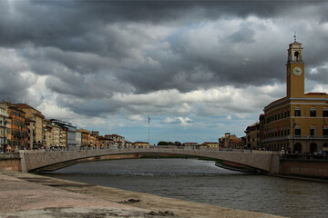Scenic panoramic landscape of medieval Pisa. Solferino bridge over Arno river. Colorful vintage buildings along embankment. Downtown of Pisa. Typical architecture of Tuscany region, Italy