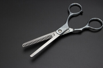 Hairdresser scissors on black background. Steel hairdresser shears. Accessories for barbershop boutique.