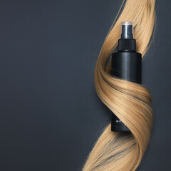 Blond wavy hair and Hair care spray on black background. Hairdresser service, hair strength,...