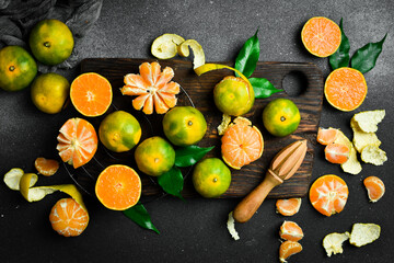 Fresh ripe Tangerine orange. Top view, on a dark stone background. Autumn fruits.