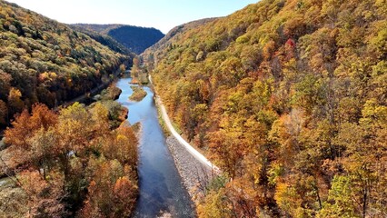 Peaceful Pine Creek flowing through mountains in Autumn Fall colors in trees at The Pennsylvania Grand Canyon vacation destination for sight seeing beautiful countryside in America.